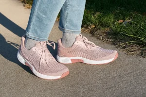 Pink sneakers on sidewalk outdoors